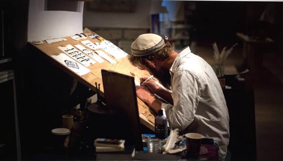 israeli scribe working on new art piece