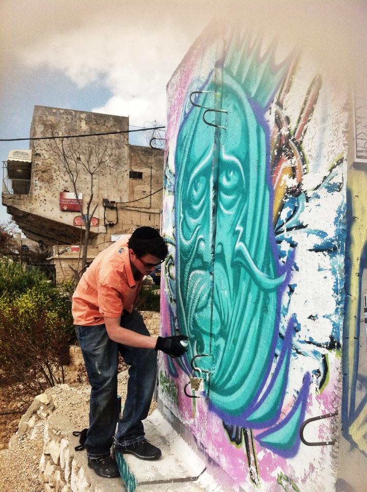Israeli street artist spray painting electricity box
