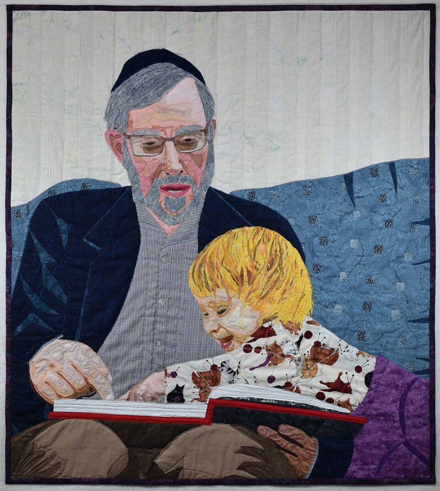 quilt design showing father and little girl reading a book