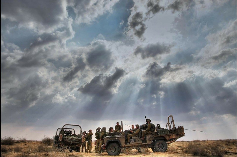 IDF soldiers in the field in military vehicles with beautiful cloudy sky