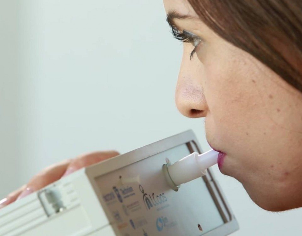 Woman breathing into device that can detect early stages of disease