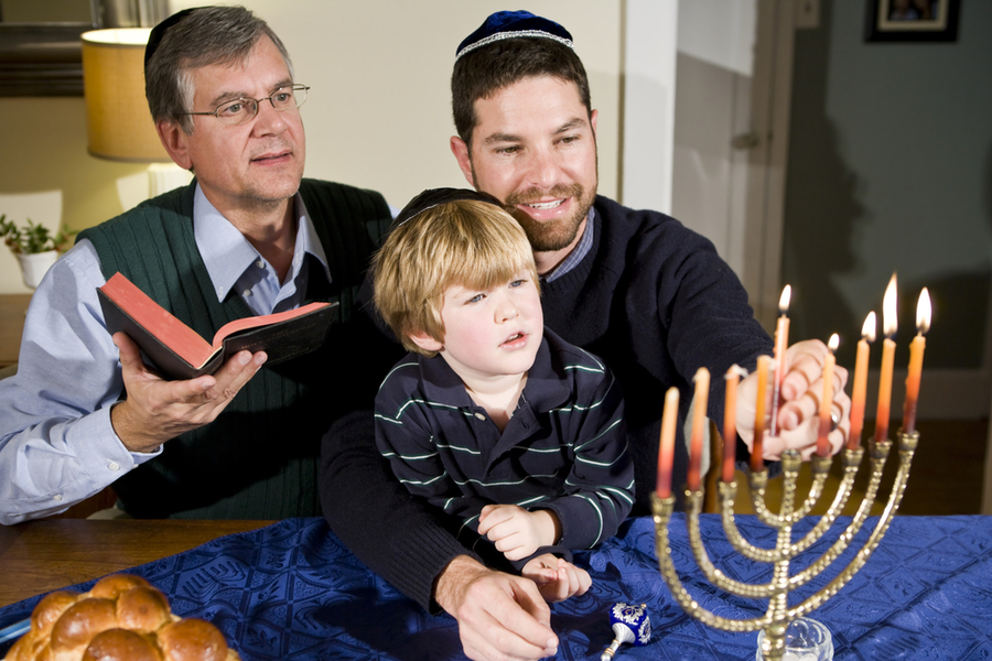 torch relay on hanukkah. father son and grandfather lighting the menorah or rather hanukiyah on Janukkah 