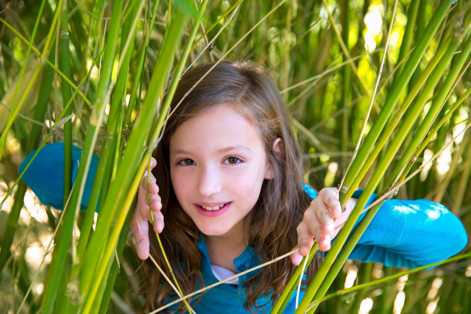 a girl hiding behind the bush to hide from a boy that likes her at tu b'av