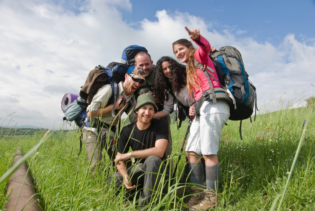 a group of young hikers taking a picture with the north of Israel view in the back 