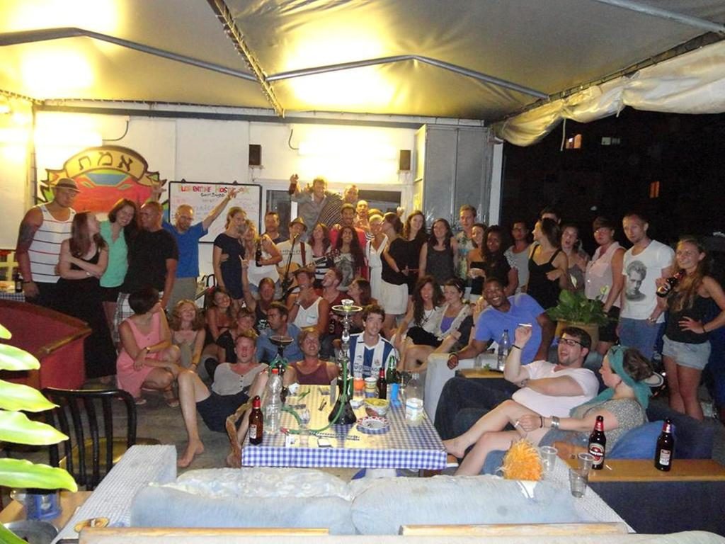 Florentine hostel in tel aviv - guests sitting around having a good time on the porch 